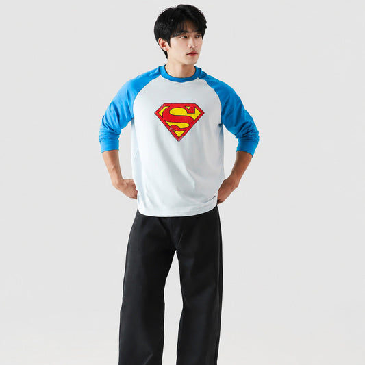 Person wearing a Superman-themed baseball shirt on a plain background
